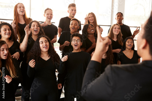 Valokuvatapetti Male And Female Students Singing In Choir With Teacher At Performing Arts School