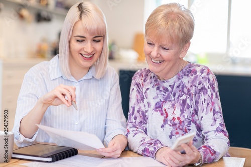 Obraz na płótnie Financial Advisor Helping Senior Neighbor With Paperwork