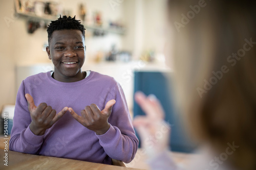 Teenage Boy And Girl Having Conversation Using Sign Language photo