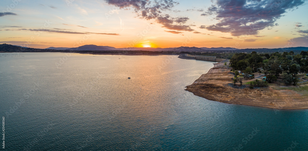 Tiny boat in a big lake at sunset - aerial panorama with copy space Tiny boat in a big lake at sunset - aerial panorama with copy space