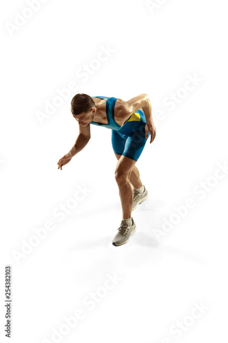 Young caucasian man preparing to run isolated on white studio background. One male runner or jogger. Silhouette of jogging athlete with shadows. © master1305