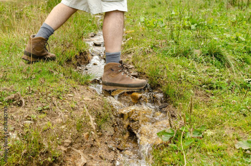 Hiker's feet while crossing a small mountain brook Hiker's feet while crossing a small mountain brook