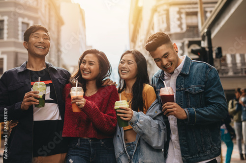 Fotografie Group of asian friends with juice in the city