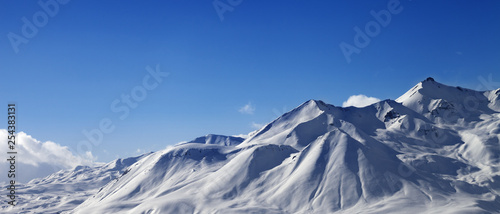 Panoramic view on snowy sunlit mountains