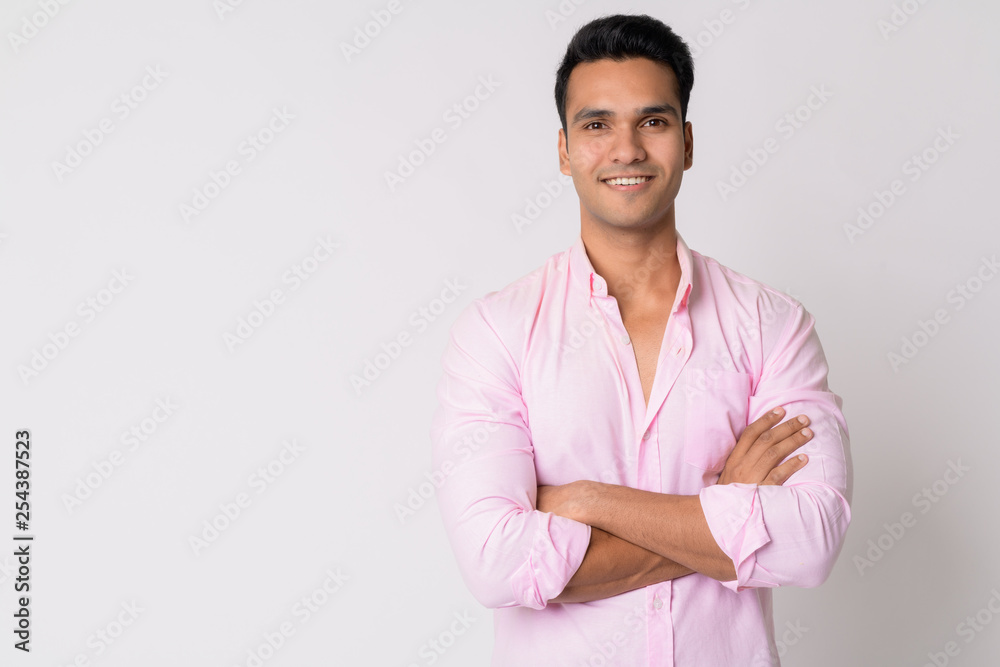 Portrait of young happy Indian businessman smiling with arms crossed Portrait of young happy Indian businessman smiling with arms crossed