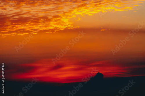 Sunny shine on clouds. Wonderful vivid dawn. Beautiful calm red sunset. Scenic surreal sunrise. Amazing scenery of orange cloudy sky. Picturesque sundown. Atmospheric cloudscape. Natural background.