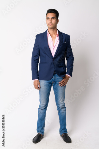 Full body shot of young Indian businessman in suit thinking © Ranta Images