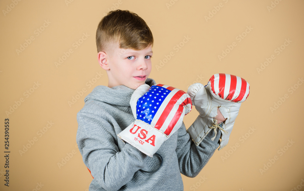 Fototapeta premium punching knockout. Fitness diet. energy health. Sport success. sportswear fashion. usa independence day. Happy child sportsman in boxing gloves. workout of small boy boxer. Feeling free and confident