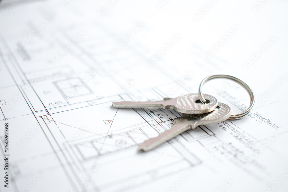 Close-up shots of new house keys on the blueprint paper that is nearing completion soon. Close-up shots of new house keys on the blueprint paper that is nearing completion soon.