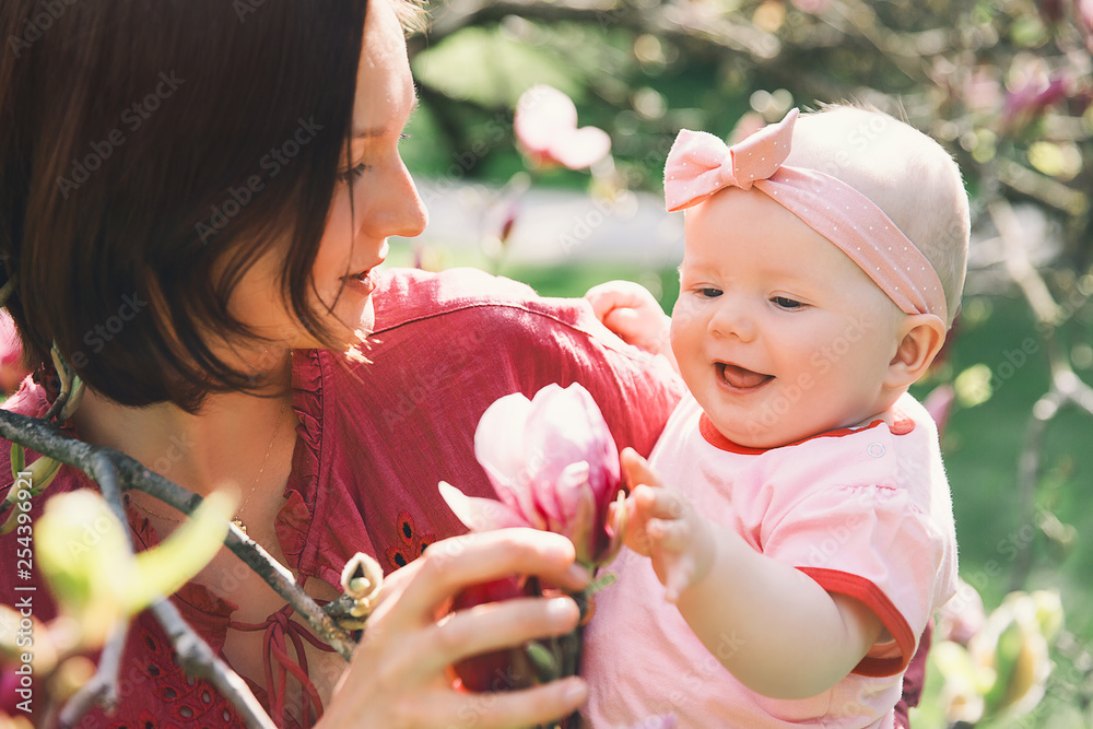 Obraz premium Mother and baby with blooming pink magnolia flower
