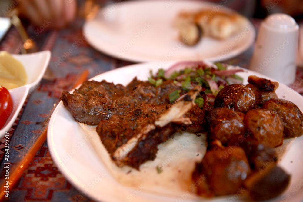 Azerbaijani Style Beef and Potato Kebab on a Plate with Onions and Bread Azerbaijani Style Beef and Potato Kebab on a Plate with Onions and Bread