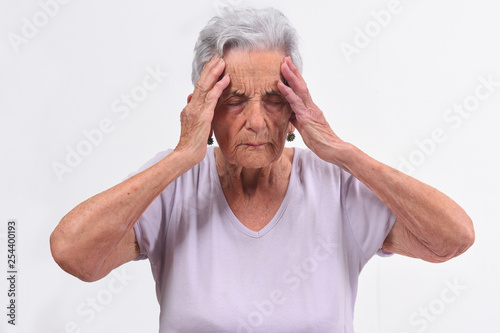 senior woman with headache on white background