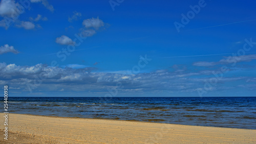 Landscape background with light clouds over Baltic sea near shoreline  selective focus