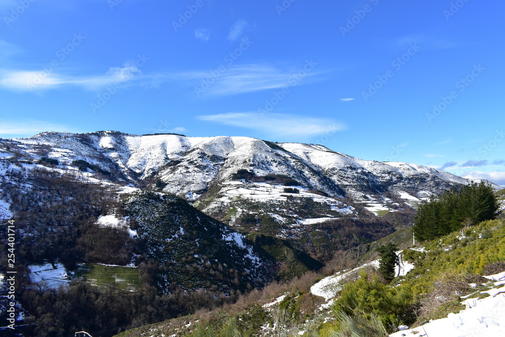 Winter landscape with snowy mountain and trees. Blue sky, Lugo, Galicia, Spain.