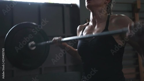 crossfit girl athlete doing exercise with a barbell. power cleans front squats slow motion