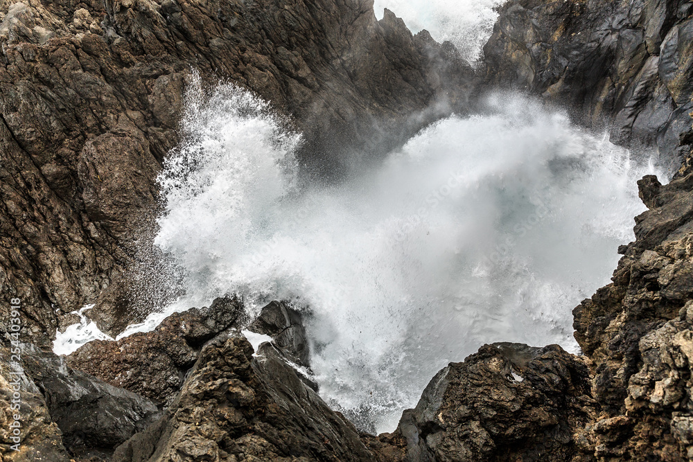 Beautiful view of the big waves crashing at the shore at Porto Moniz, on the north coast of Madeira island