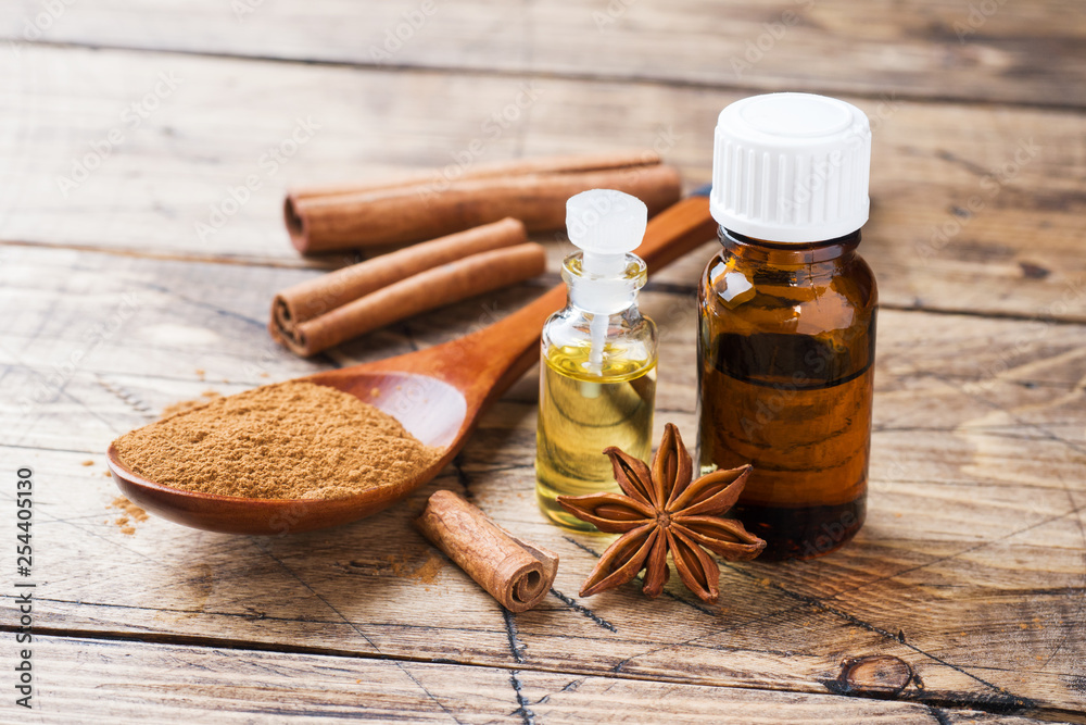 Essential aroma oil with cinnamon and star anise on wooden background. Selective focus. Essential aroma oil with cinnamon and star anise on wooden background. Selective focus.