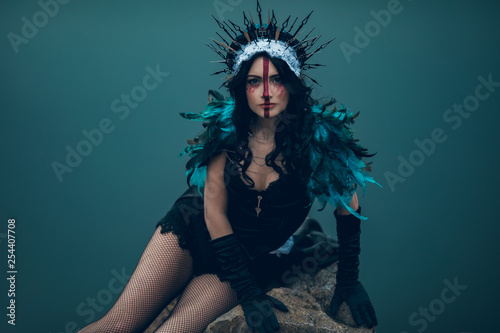 Canvastavla A young woman in the image of a fairy and a sorceress sitting on rock over a lake