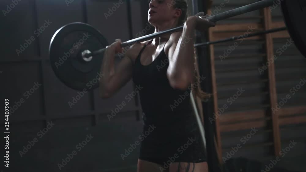 crossfit girl athlete doing exercise with a barbell. power cleans front squats slow motion close up crossfit girl athlete doing exercise with a barbell. power cleans front squats slow motion close up