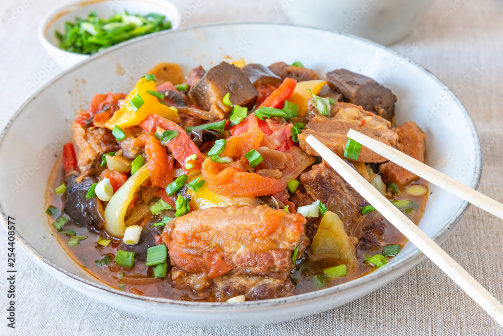 Fried pork with eggplants and sweet peppers in a large bowl - a traditional Chinese dish Fried pork with eggplants and sweet peppers in a large bowl - a traditional Chinese dish