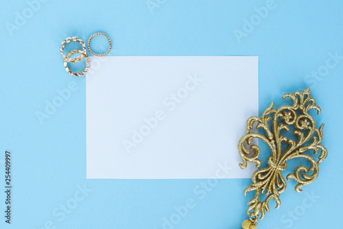 flatley on turquoise background with white paper sheet for text and fern leaves,  top view, space for text, copy space, © Irina