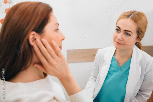 Doctor listens to the patient's complaints while the patient points to the ear. Otitis, showing ear pain