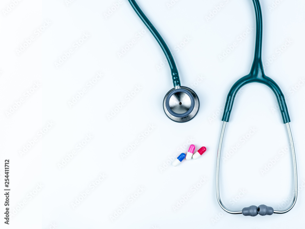 Top view of green stethoscope with pile of antibiotic capsule pills on  white table. Antimicrobial drug resistance and overuse. Medical equipment  for doctor. Clinical Cardiology. Global Health care. Stock Photo | Adobe