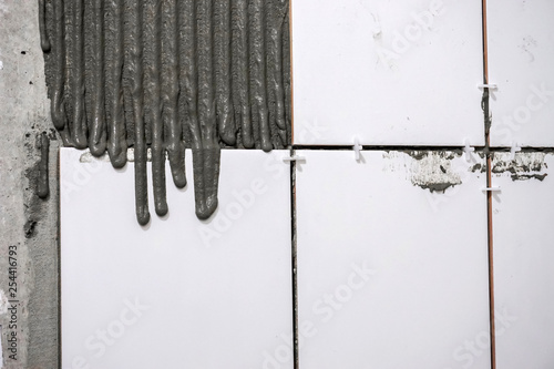 man is not a professional badly puts tile in the bathroom with his own hands