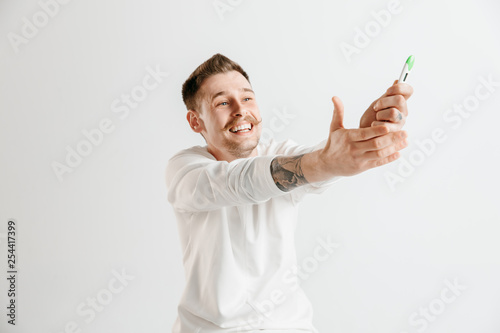 Happy man looking at pregnancy test at studio. Human emotions concepts