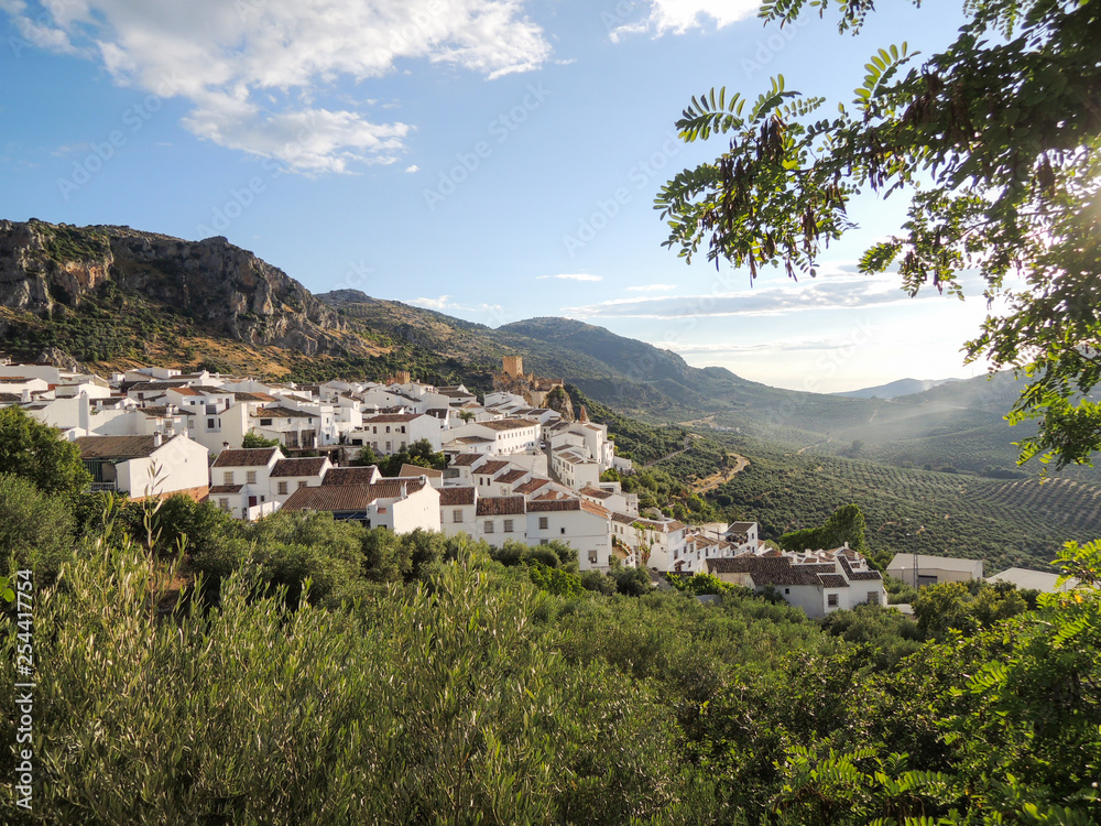 White village on a hillside with olive vineyards, in the Spanish region of andalusia