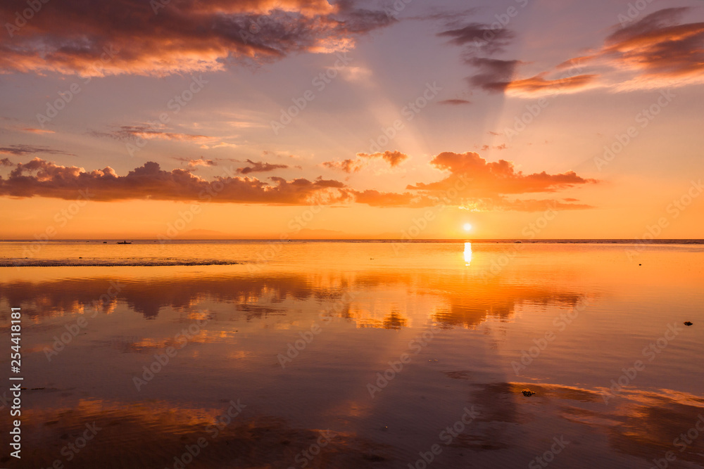 sunset at a beach, the sea in low tide, a tranquil scene in a summer evening vacation mood 