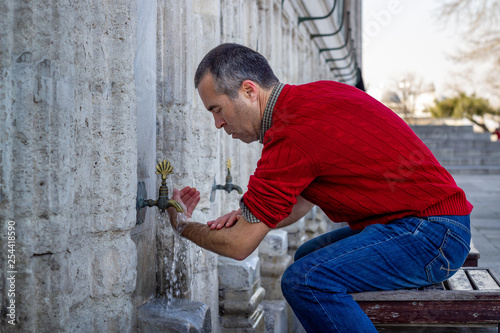 Photography Muslim man taking ablution for prayer