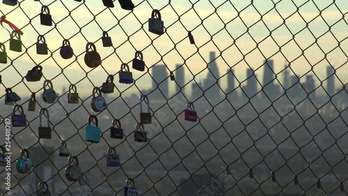Love lock padlocks on fence overlook Los Angeles Skyline 