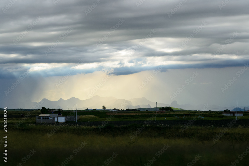 Brazilian landscape, road trip in the Espirito Santo state. Wide valleys, nice greenery of atlantic forest and mountains in the background with a cloudy sky after rain