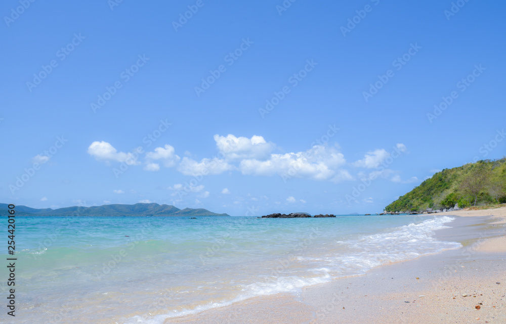 Beautiful beach with soft wave of tropical sea and blue sky. Summer day and sandy beach background. Vacation holidays background wallpaper.