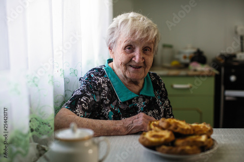 Elderly woman sitting in the kitchen.