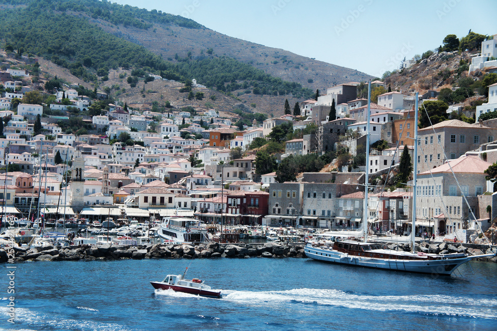 The panoramic view of Greek island Hydra with a motor boat on the foreground, edited in Instagram style. Perfect wedding location. 