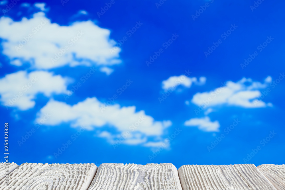 White wooden table with empty space on blue sky background