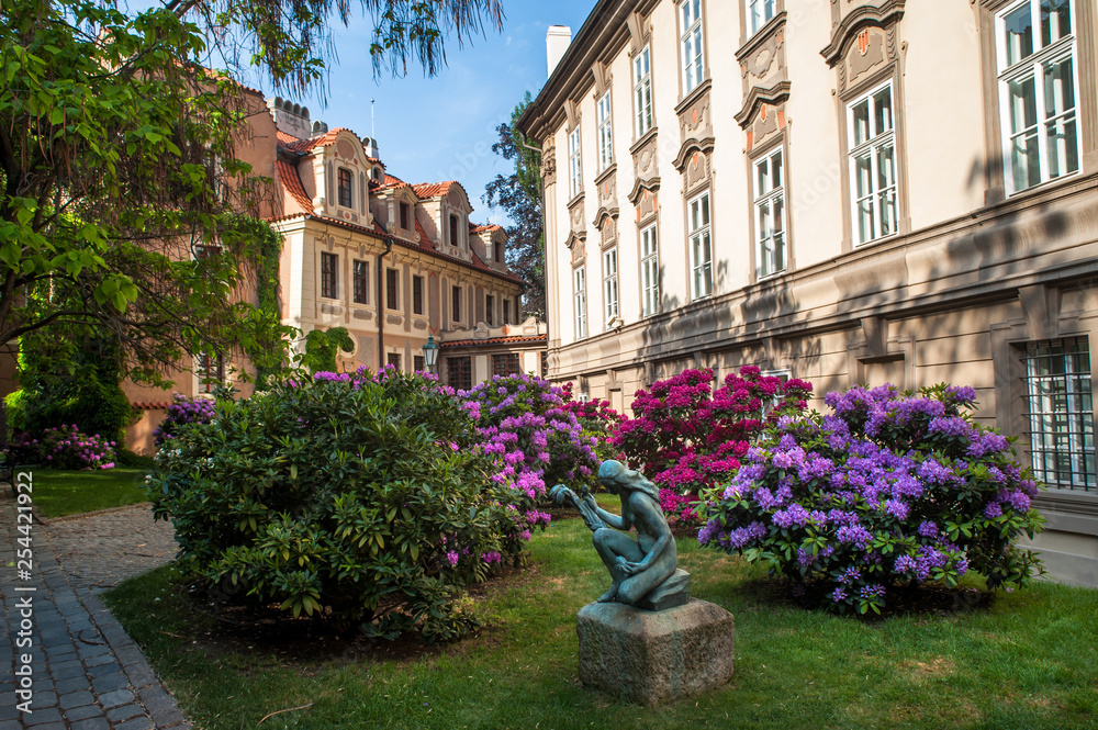 Sculpture with blooming Rhododendrons in Prague Kolowrat Garden