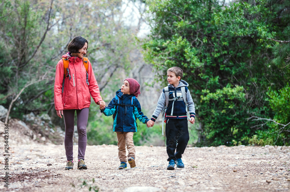 A woman with two children goes through the forest. A woman with two children goes through the forest.