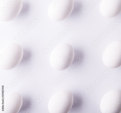 White eggs on a white background. Easter and spring flat lay. Top view.