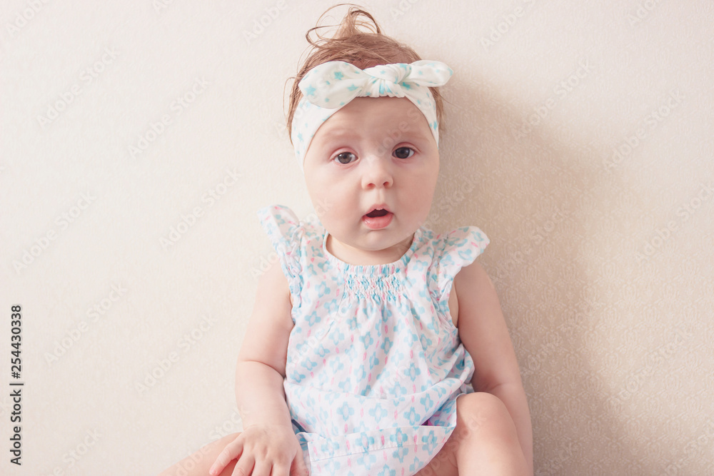 Portrait of eight month girl in the dress with headband, indoors Portrait of eight month girl in the dress with headband, indoors