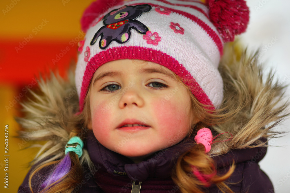 Closeup outdoor portrait of pink cheeked three year old toddler girl with colorful braided hair Closeup outdoor portrait of pink cheeked three year old toddler girl with colorful braided hair
