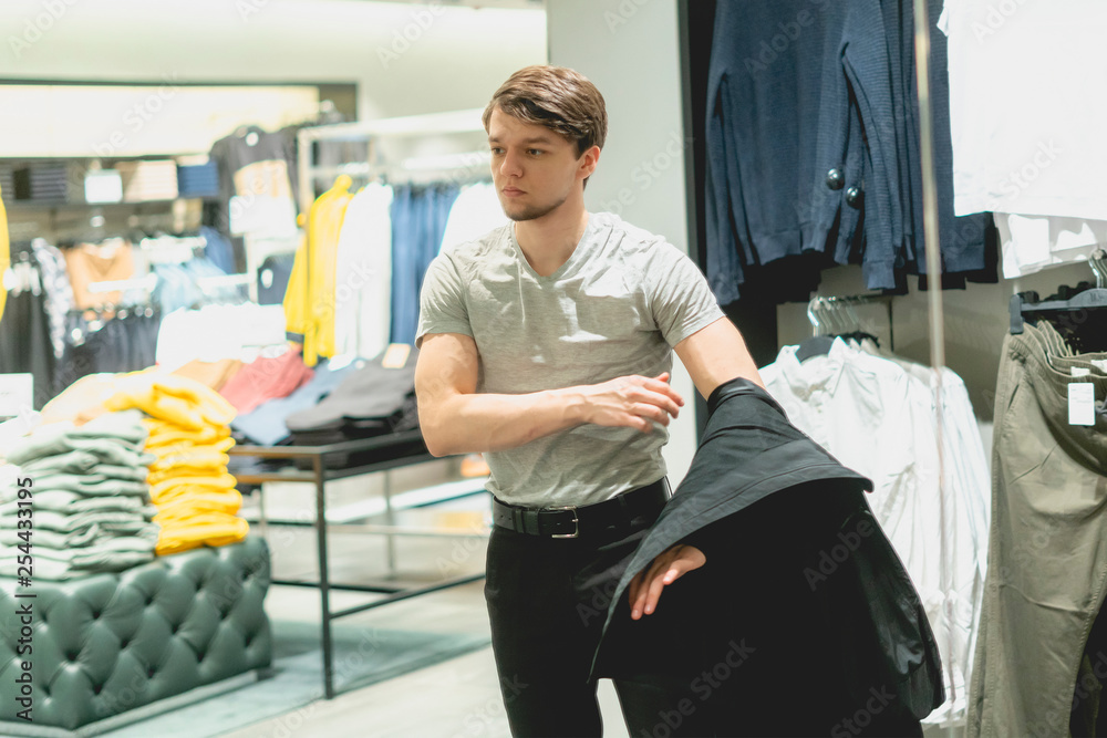 young businessman try on new jacket in the store young businessman try on new jacket in the store