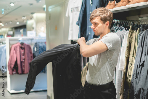 young businessman try on new jacket in the store