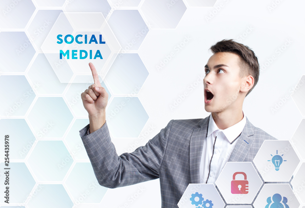 The concept of business, technology, the Internet and the network. A young entrepreneur working on a virtual screen of the future and sees the inscription: Social media The concept of business, technology, the Internet and the network. A young entrepreneur working on a virtual screen of the future and sees the inscription: Social media