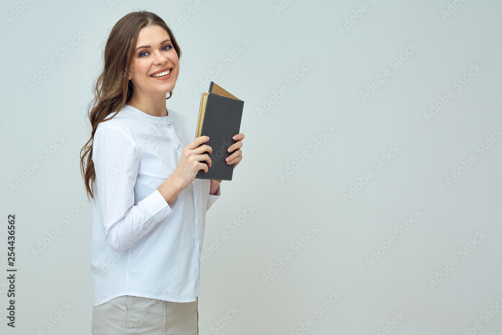 Smiling woman teacher wearing white shirt holding books. Smiling woman teacher wearing white shirt holding books.