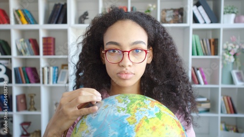 Beautiful african american student with globe in her hands