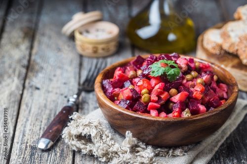 Russian beetroot salad vinaigrette in wooden bowl with rye bread  rustic background