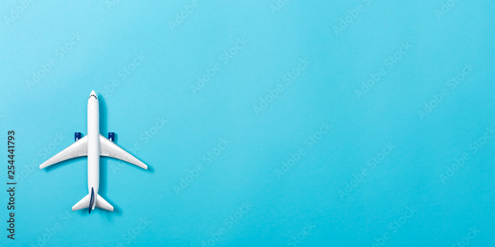 A toy airplane on a blue paper background A toy airplane on a blue paper background